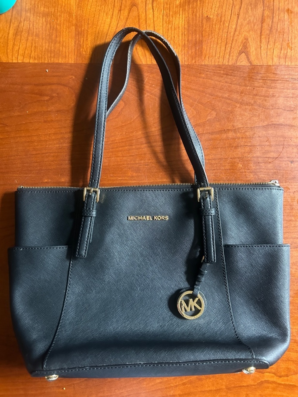Michael Kors bag on black with gold hardware